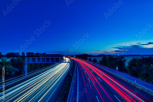 German Autobahn at Sunset with Long Exposure Light Trails and Gantry Sign