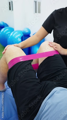 Physical therapist helping patient with leg muscle strengthening exercise
