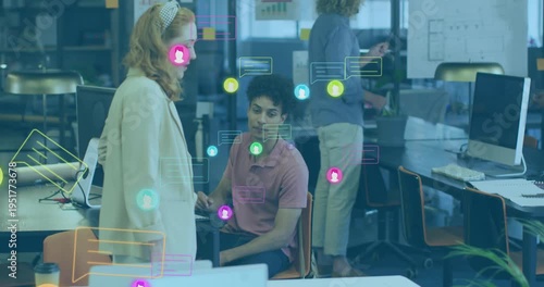 Standing woman coming to seated man, reviewing biz plan while social icons floating, obscuring team