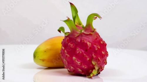 Vibrant dragon fruit and mango on white surface with copy space