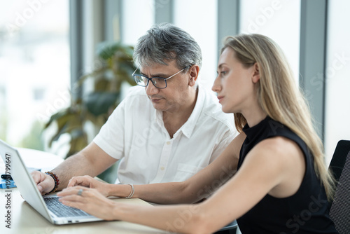 Two business man and woman working with computer notebook in office room 