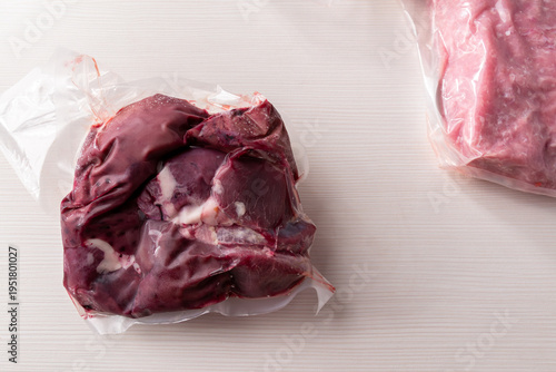 Fotografie Organic raw turkey offal and ground meat in vacuum sealed bags, frozen bio poultry giblets for healthy meal prep