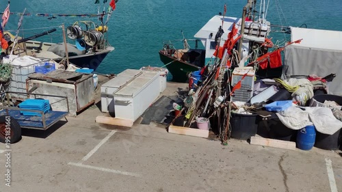 Fishing port of Las Casas de Alcanar in Catalonia, Spain. View of the boats with traditional fishing gear moored at the dock. Smooth camera movement: Track + Panning Left.