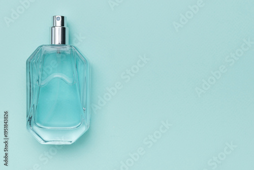 Sleek Glass Perfume Bottle with Light Blue Liquid on Minimalist Turquoise Background