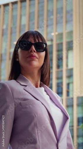 Portrait of indian or Latin confident successful ceo manager female businesswoman. Young hispanic woman in stylish business clothes, sunglasses walking outdoors at modern office building. Vertical