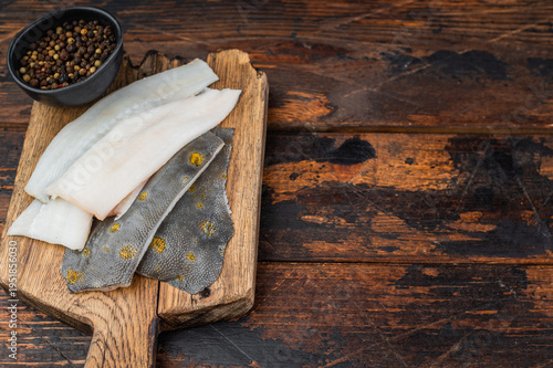 Fotografie Fresh plaice flatfish fillets on wooden board with spices raw seafood ingredient