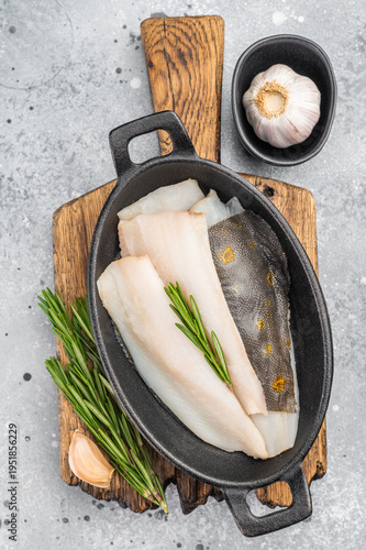 Tableau sur toile Fresh dab flatfish fillets with herbs and garlic in cast iron pan, raw seafood i