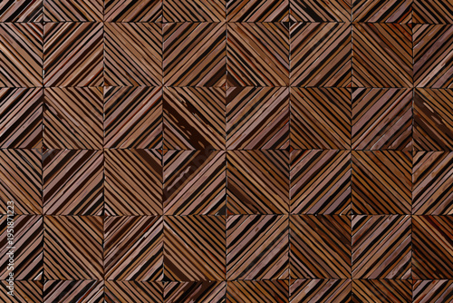 Intricate wooden wall paneling featuring a geometric chevron like pattern