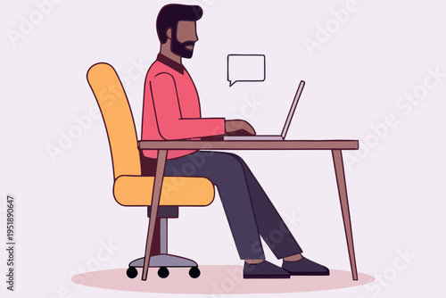 A man working on a laptop at a desk in a modern office space