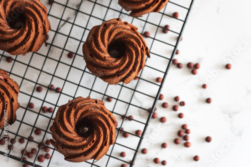 Schilderij op canvas Mini chocolate bundt cakes on a cooling rack. Top view