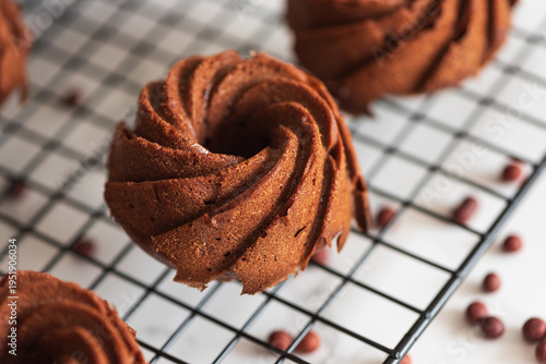 Foto Mini chocolate bundt cakes on a cooling rack. Soft focus