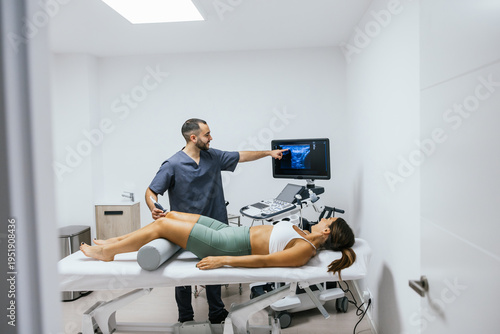 Physiotherapist performing an ultrasound scan on a female patient's knee in a clean clinic, identifying musculoskeletal issues for diagnosis