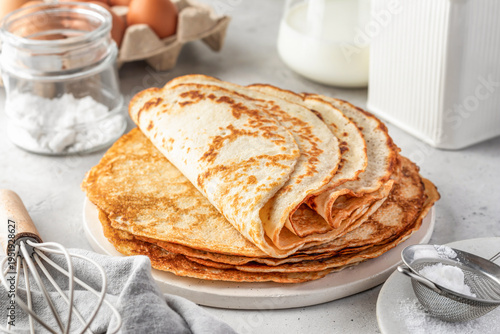 Stack of delicious crepes folded on light gray table background
