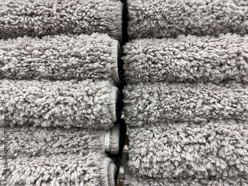 Neatly stacked rolls of soft gray towels with dense, fluffy texture, creating a clean, cozy, and uniform display suitable for home, spa, or retail settings.