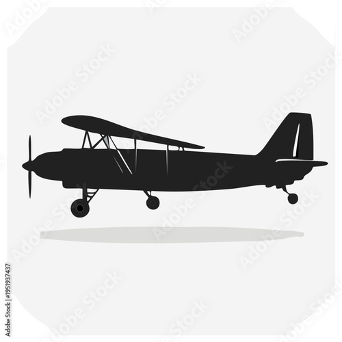 Silhouette of a classic biplane aircraft in profile view against a light grey background