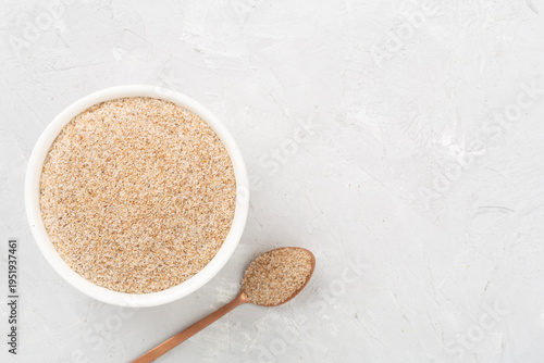 Tableau sur toile Psyllium husk powder with fresh leaves on concrete background, top view