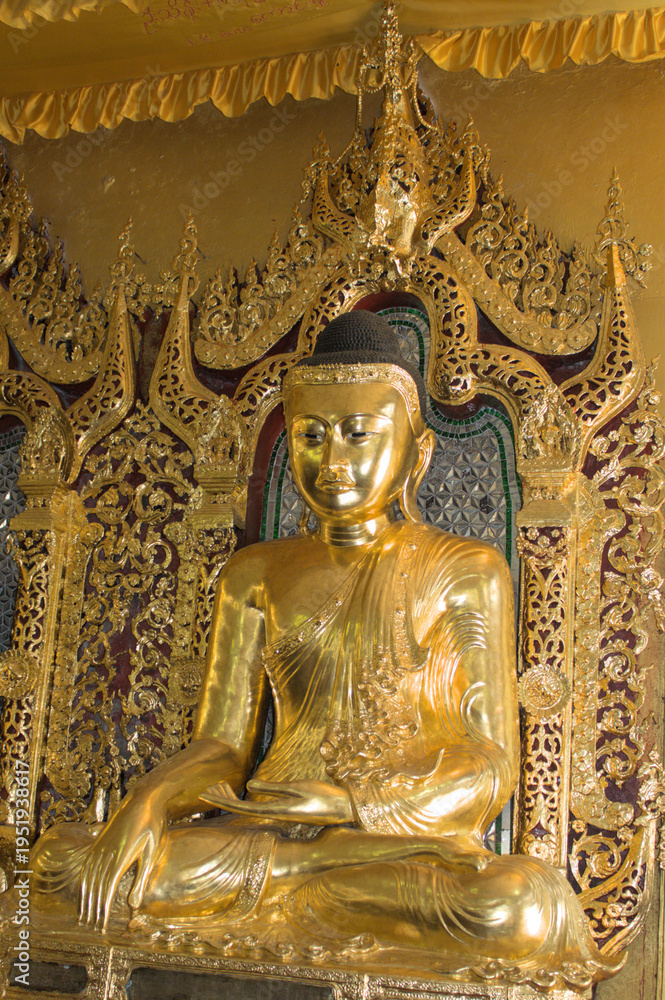 Obraz premium Golden Buddha statue inside ornate Buddhist temple in Yangon, Myanmar