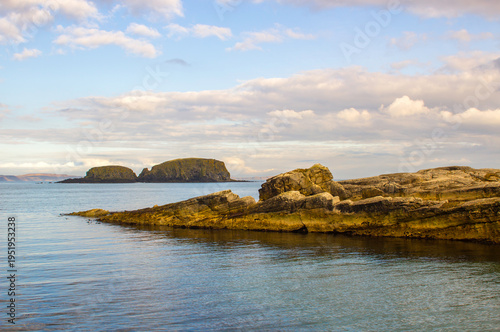 The rocky entrance to the small harbour at Ballintoy on the North Antrim Coast of Northern Ireland on a calm spring day.