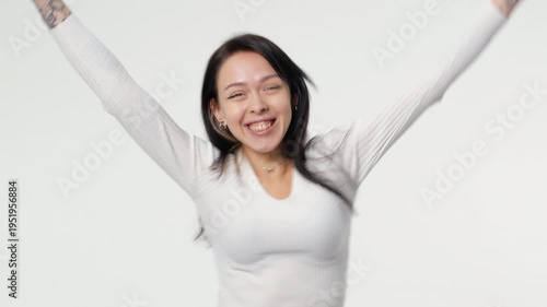 A confident young woman gracefully poses with a relaxed demeanor, beautifully showcasing her stunning beauty and poise