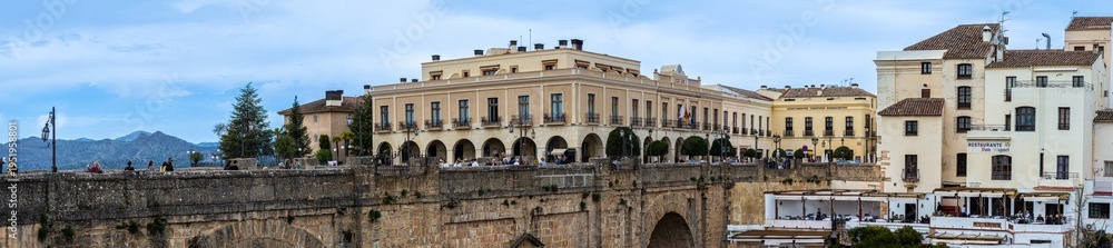 Fototapeta premium Puente Nuevo dramatic bridge spanning a deep limestone gorge creating iconic architectural landmark in Ronda, Spain.