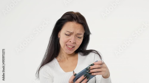Adult young woman holds phone looks at phone play game white background isolated space