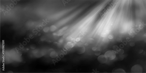 Abstract ethereal grayscale image of light rays, casting down, illuminating the dark, adding a sense of mystery and depth. The image captures the contrast of light and shadow.