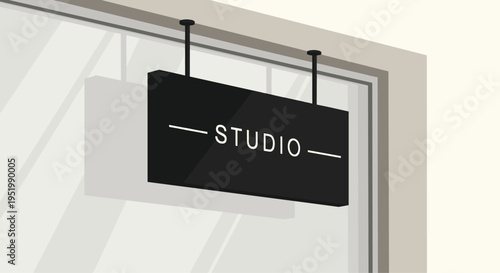 A black rectangular sign displaying STUDIO in white text hangs from two rods on a building's light gray window frame.