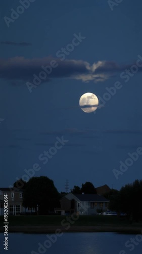 Moonlight over suburban homes at dusk.