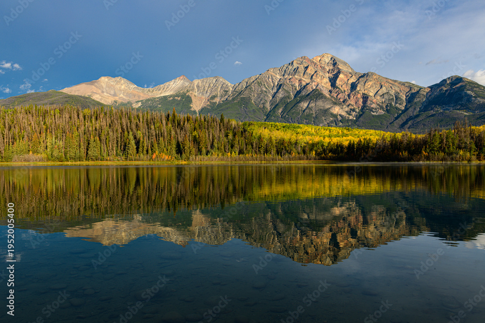 Fototapeta premium Autumn forest reflected in Patricia Lake under clear blue sky