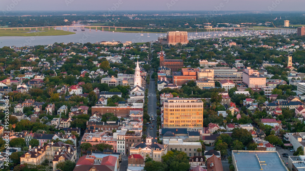 Naklejka premium Aerial View of Broad Street in downtown Charleston, South Carolina cityscape landscape showcasing city streets, historic churches and building during morning sunrise light with boat harbor in distance