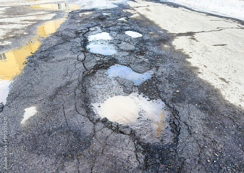 Nid-de-poule dans la rue au printemps	