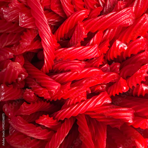 Vivid close-up of bright red twisted licorice candy pieces piled together