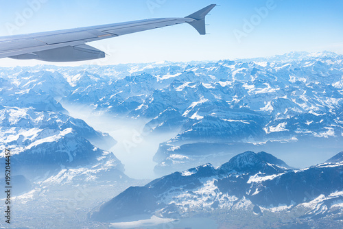 Unique alpine aerial panorama. Blue Planet Earth high altitude aerial view of Swiss Alps lakes, seen from an airplane cabin window. Travel, transportation concept.