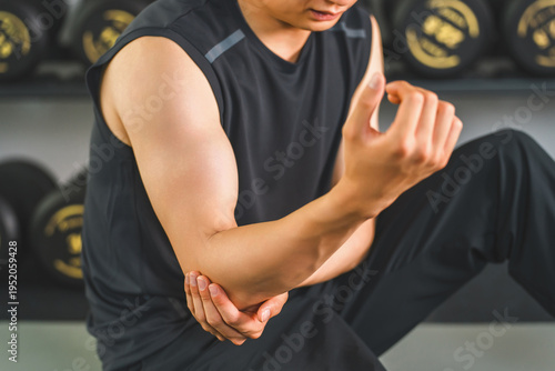 Tableau sur toile A young Asian man complains of elbow pain while training at the gym