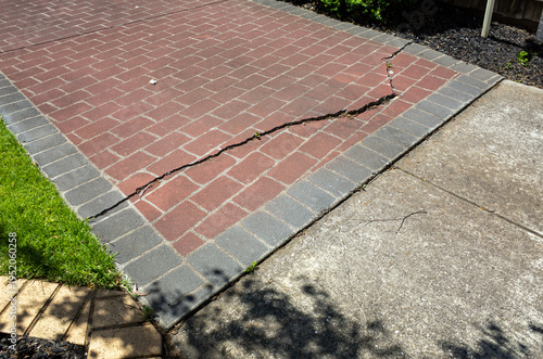 Картината върху платно Cracked brick driveway in a residential property, showing surface damage and structural wear