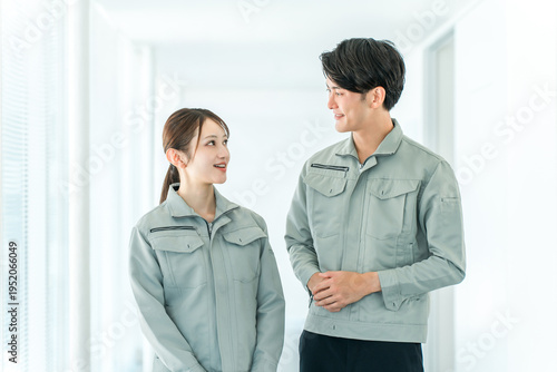 Fotografie Male and female factory workers wearing work clothes.