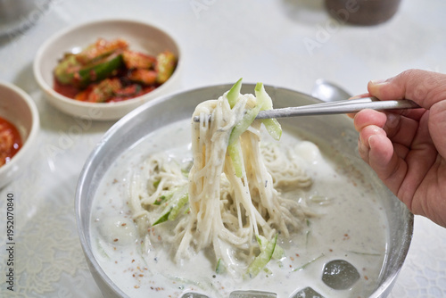 These images showcase Kongguksu, a refreshing Korean cold noodle dish featuring creamy soy milk broth, chewy noodles, and fresh cucumber garnishes.