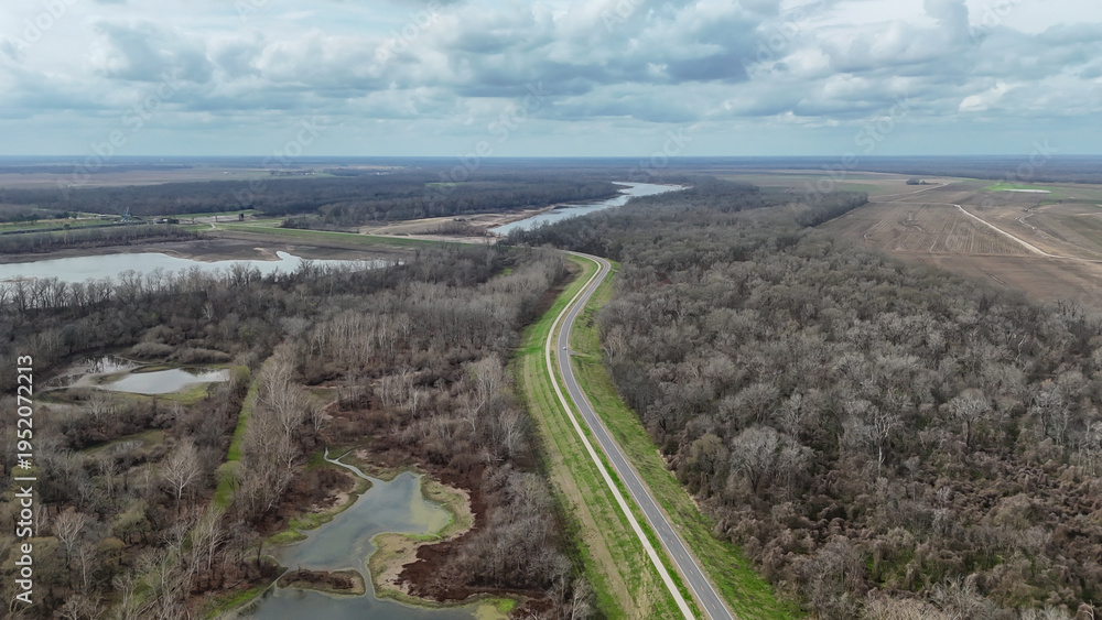 Obraz premium Winding la 15 cuts through a vast winter landscape of bare trees, wetlands and swamps, lakes nearby and the mississippi river on the horizon near vidalia, louisiana