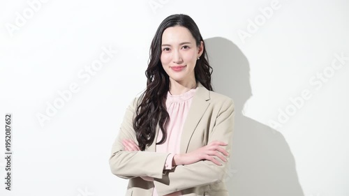 かわいいスーツの日本人女性のカメラ目線の笑顔　多幸感や成功や自信あふれる春色ビジネスイメージのスローモーション動画　転職や採用