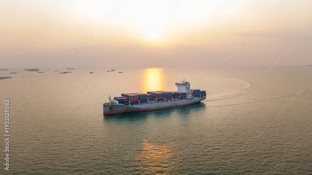 Fototapeta premium Large container ship loaded with cargo navigating the calm sea at sunset. Global trade logistics, maritime commercial freight transport, and energy commodity supply chain concept.