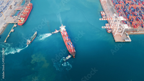 large container ship assisted by tugboats near a busy commercial port and terminal. Global maritime trade logistics, freight transport, and energy commodity supply chain concept.