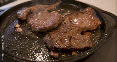 Delicious, sizzling steak on pan - closeup, steady cam movement 