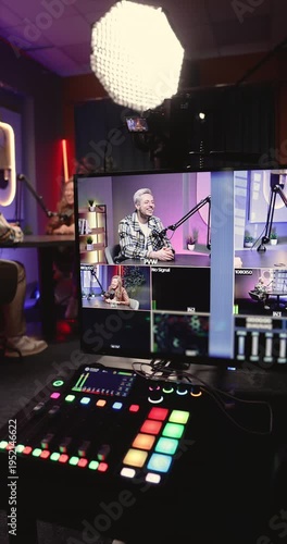 Close up modern podcast studio with hosts recording interview, with professional lighting, microphones, live production monitor displays multiple cameras. Media production in creative broadcast space