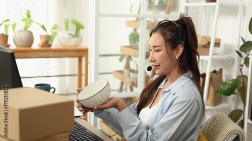Customer, support, service, communication, ecommerce, telemarketing seller woman examines ceramic bowl while on headset call, discussing product details and quality with buyer from home business work