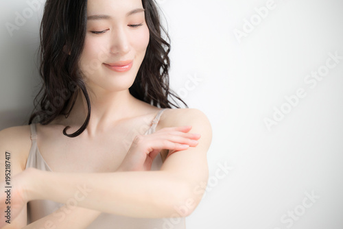 腕にクリームや日焼け止めを塗る美容イメージ　白背景