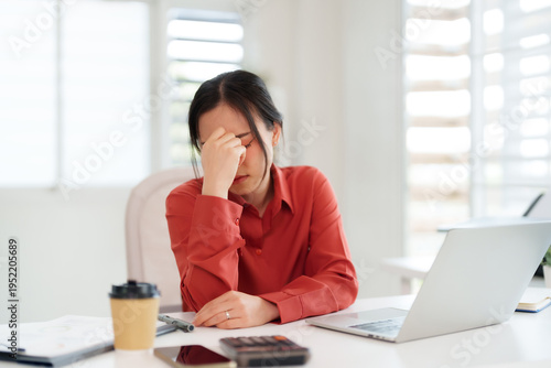 Fotografie Asian adult businesswoman experiencing work related stress and financial pressur