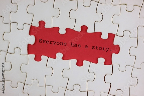 White Puzzle With red Missing Piece Reading 'Everyone Has a Story'. symbolizes the identity, life experiences, and uniqueness of each individual.