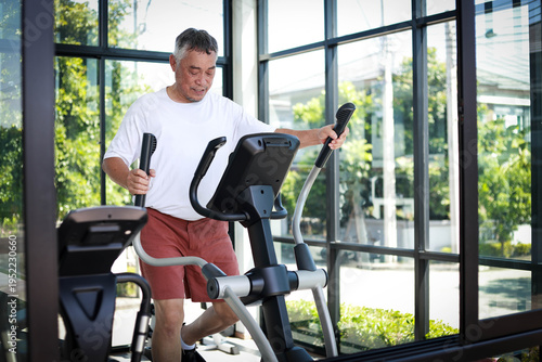 Fotografie Elderly man maintains his health by doing cardio exercises in a brightly lit gym, reflecting a modern and active lifestyle
