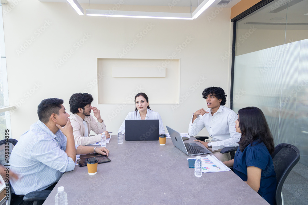 Fototapeta premium Young indian business people or office employee sitting in meeting room discuss work with female boss. Corporate job. Teamwork.