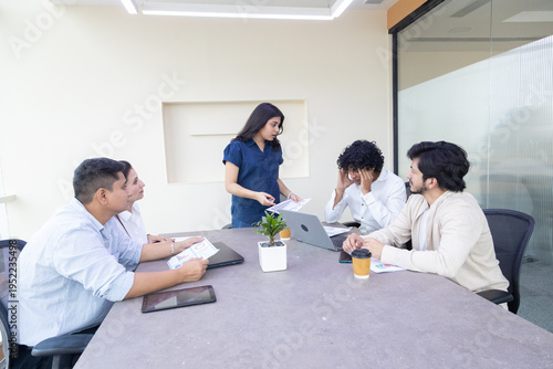 Indian female boss entrepreneur expressing dissatisfaction with employees or colleague and pointing mistake in project report or Businesswoman unhappy with performance of team. Loss of company